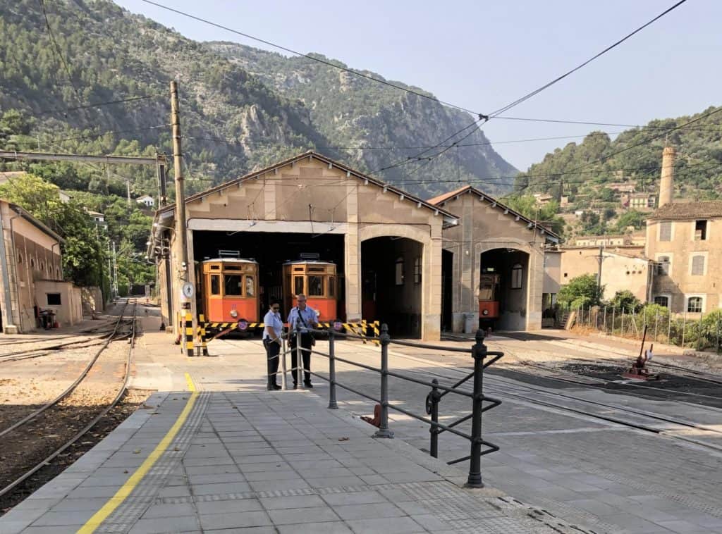 Soller Mallorca Tramuntana Mountains Train Station With Two Train Conductors And Orange Trains