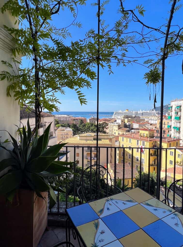 Salerno Minerva Garden Cafe Table View Of Sea And Yellow Buildings Vines Plants And Trellis