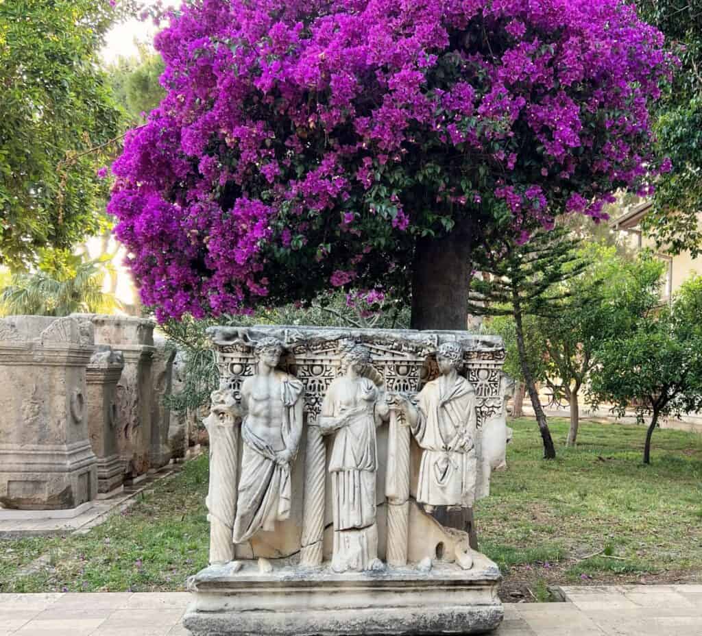 Ancient Statue Under Purple Bougainvillea Sculpture Garden Antalya Archeological Museum